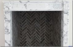 a marble fireplace surround with herringbone pattern