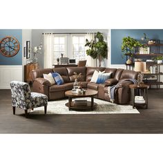 a living room with blue walls and brown leather furniture in the center, along with a large clock on the wall