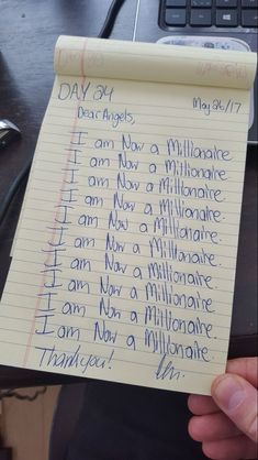 someone holding up a piece of paper with writing on it that says, i am now a millionaire