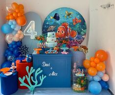 an under the sea themed birthday party with balloons, cake and other items on display