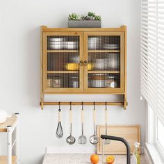 a kitchen with wooden cabinets and utensils hanging from the wall