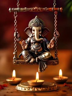 an elephant statue sitting on top of a swing with candles in front of it,