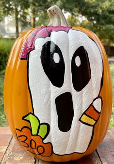 a painted pumpkin with a ghost face on it