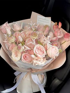 a bouquet of pink flowers sitting in the back seat of a car