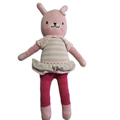 a pink and white stuffed animal wearing a dress with stripes on it's legs