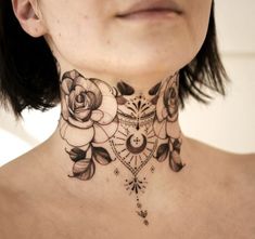 a woman wearing a black and white neck tattoo with flowers on her neck is looking at the camera