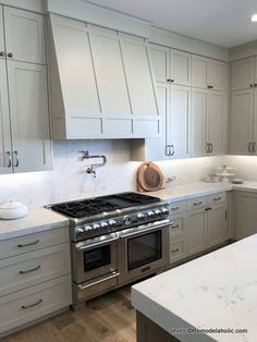 a kitchen with white cabinets and stainless steel appliances