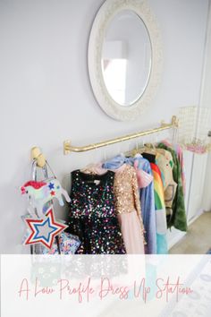 a closet with clothes hanging on the rack and a mirror above it that says, a few people dress up station