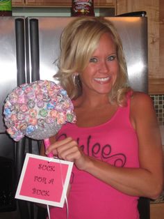 a woman in pink shirt holding up a pinwheel with flowers on top of it