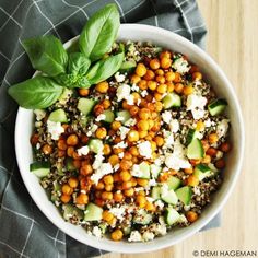 a white bowl filled with chickpeas, cucumber and feta cheese