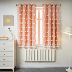 an orange and white curtain hangs in front of a window