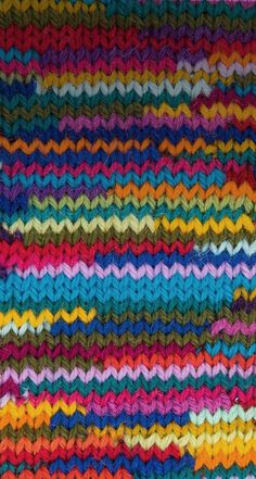 a multicolored knitted blanket with wavy lines