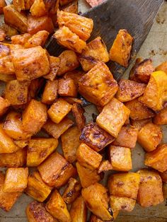 roasted potatoes on a baking sheet with a spatula