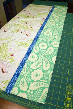 two strips of fabric are laid out on a cutting board to be sewn together