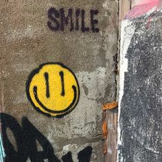 graffiti on the side of a building with a smiley face painted on it