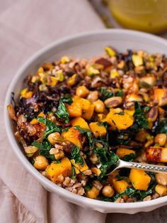 a white bowl filled with vegetables and nuts