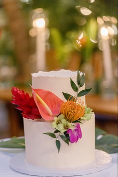 a wedding cake decorated with flowers and greenery