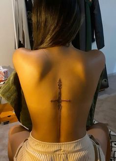 a woman with a cross tattoo on her back