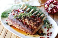 a white plate topped with meat covered in cranberry sauce and garnish