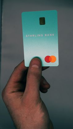 a hand holding up a credit card with the words starling bank printed on it