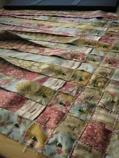 an old quilt is laying on top of a table