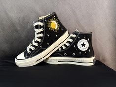 Converse Custom, The Moon Hugs the Sun Embroidered Converse High Tops, Converse embroidered, Black Converse embroidered High Tops for girls Wearing hand-embroidered Converse shoes with a personal touch offers many benefits. Here are some of the key advantages: 👉Unique Style: Each pair of hand-embroidered Converse shoes is one-of-a-kind. Because they are crafted with care, no two pairs are the same. This helps you stand out and show off your unique style. 👉Artistic Craftsmanship: These shoes highlight the talents of skilled artisans. The detailed designs and embroidery on Converse shoes reflect the dedication and artistry that goes into making them. 👉Personal Expression: Custom embroidery on Converse shoes allows you to add designs that reflect your interests, hobbies, or personality. Yo Embroidered Black Converse, Black Converse Embroidery, Heartstopper Converse, Converse Customized, Embroidered Converse High Tops, Converse Haute, Embroidery Converse, Converse Embroidery, Embroidered Converse