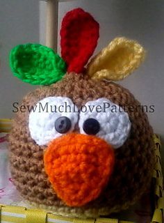 a crocheted stuffed bird is sitting in a basket with its eyes wide open