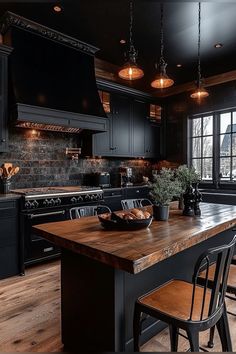 a large kitchen with black cabinets and wooden counter tops, along with two chairs at the island