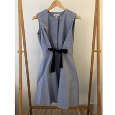 97%Cotton 3% Elastane, This Button Up Sleeveless Dress Is In A Soft Slate Blue With A Black Knit Bow That Creates A Cinched Waist And Inverted Pleat When Tied. Princess Seams In The Front And Back Create The Perfect Fit Without Bulk. And Like All Amazing Dresses, It Has Pockets!! Never Worn With Tags Blue Cotton Sleeveless Dress For Work, Blue Fitted Sleeveless Dress For Daywear, Spring Sleeveless Dress With Bow For Dress-up, Blue A-line Sleeveless Dress For Daywear, Blue Collared Mini Dress With Button Closure, Fitted Button-up Shirt Dress With Pleated Waist, Blue Button-up Mini Dress With Pockets, Light Blue Button-up Dress With Button Closure, Knit Bow