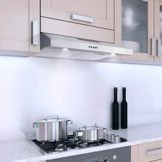 a stove top oven sitting next to two pots and pans on a kitchen counter