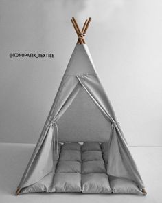 a teepee tent with pillows and bamboo sticks sticking out of it's sides