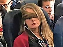 a woman with headphones sitting on an airplane