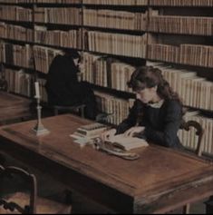 two people sitting at a table in a library