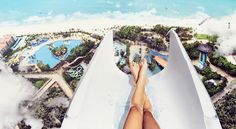 an aerial view of a person laying in a water slide at the edge of a beach