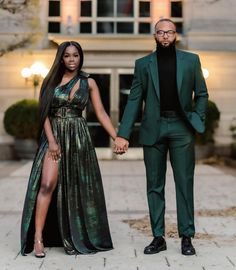 a man and woman holding hands in front of a building