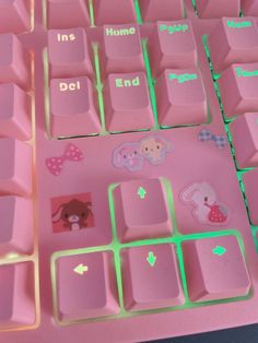 a pink keyboard with green keys and stickers on the backlit top part,