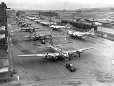 an old black and white photo of airplanes parked on the tarmac at an airport