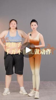 two women standing next to each other in front of a gray wall with chinese characters on it