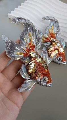 two goldfish brooches sitting on top of a table