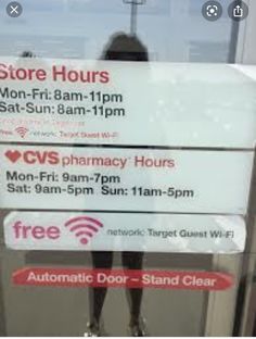 an advertisement for the store hours are displayed in front of a glass door with a woman's silhouette on it