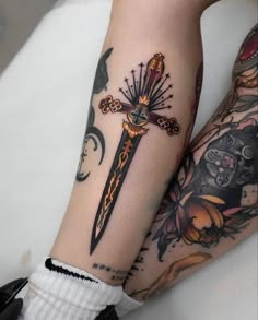 two people with tattoos on their legs and one is holding a knife in the other hand