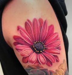 a woman's arm with a pink flower on the left side of her body