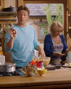 a man and woman in the kitchen preparing food