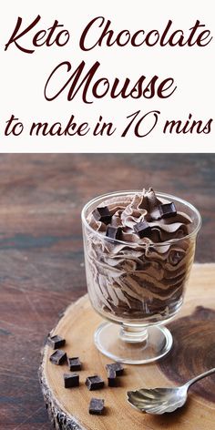 a glass bowl filled with chocolate mousse on top of a wooden board