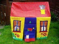 a child's play house made out of cardboard with windows and doors on the front