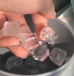 someone is holding some ice cubes in a bowl