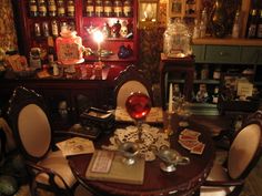 a table with many items on it in a room filled with shelves and other things