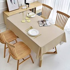 the table is set for four with plates and silverware on it in front of a window