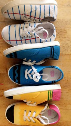 four pairs of colorful shoes lined up on a wooden surface with one shoe in the middle