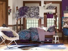 a bed with purple and blue comforters in a room